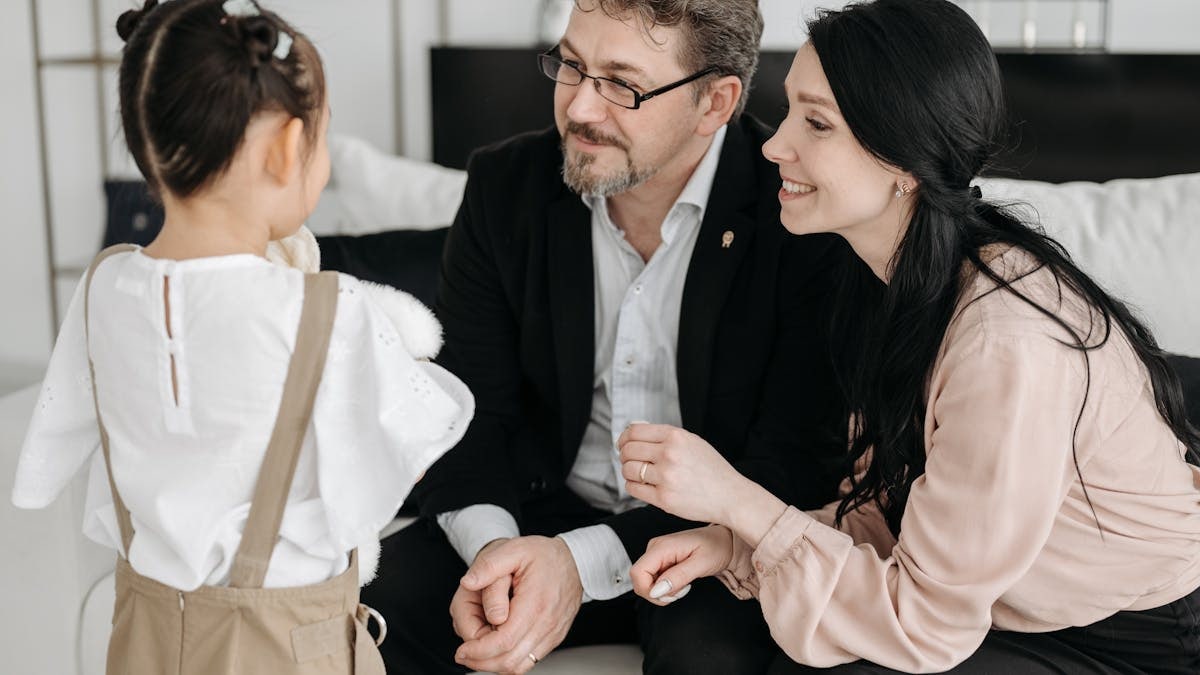 A joyful moment shared between parents and their child in a cozy indoor setting.